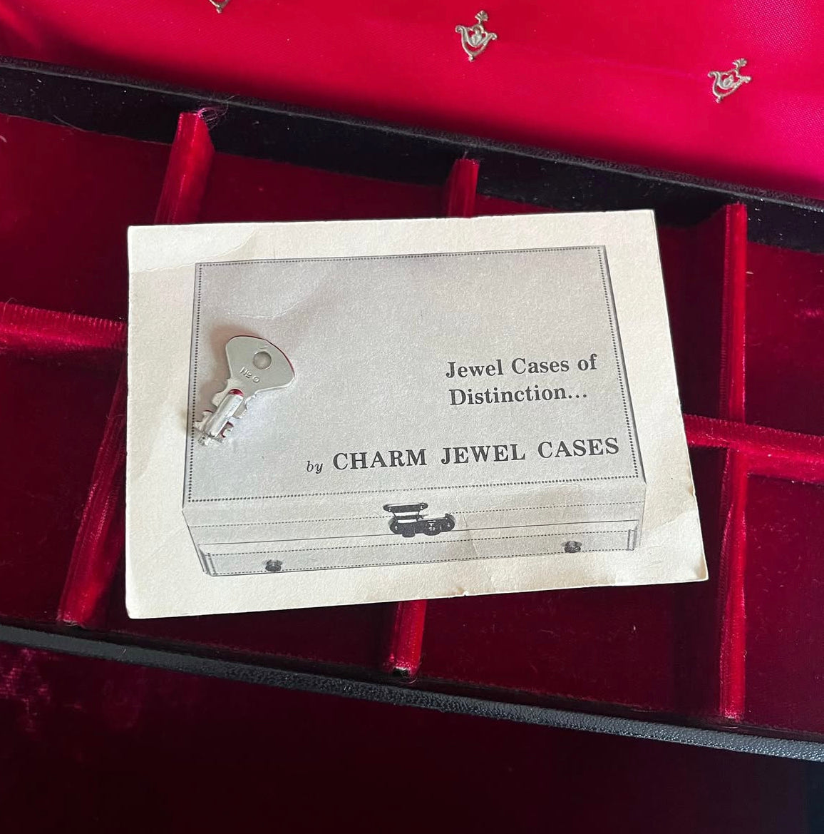 Vintage black vinyl covered jewelry box with gold accents, red velvet and satin interior