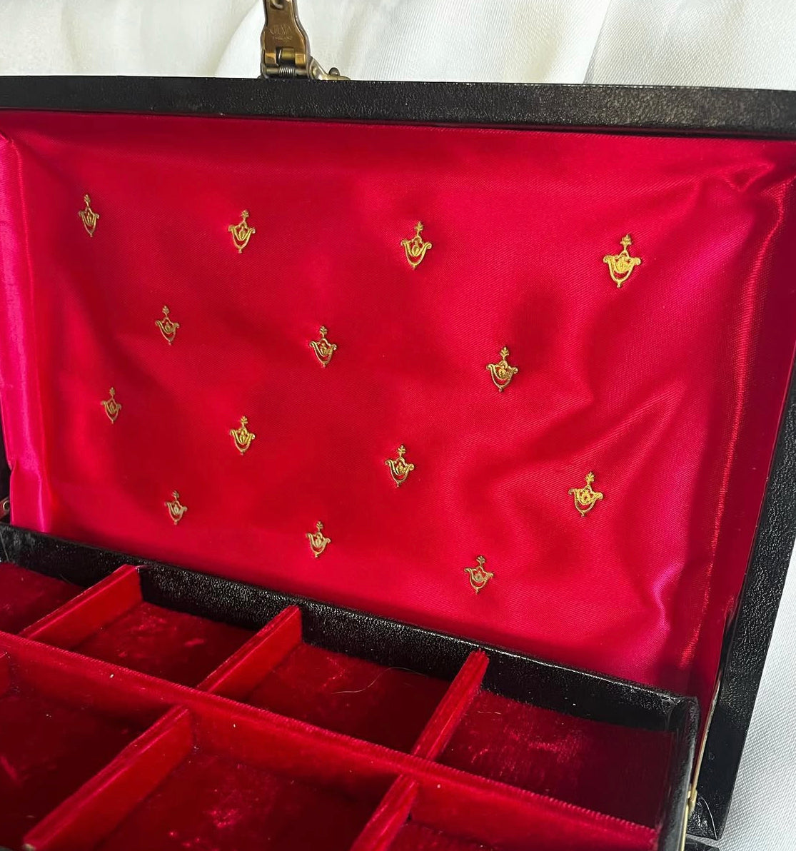 Vintage black vinyl covered jewelry box with gold accents, red velvet and satin interior