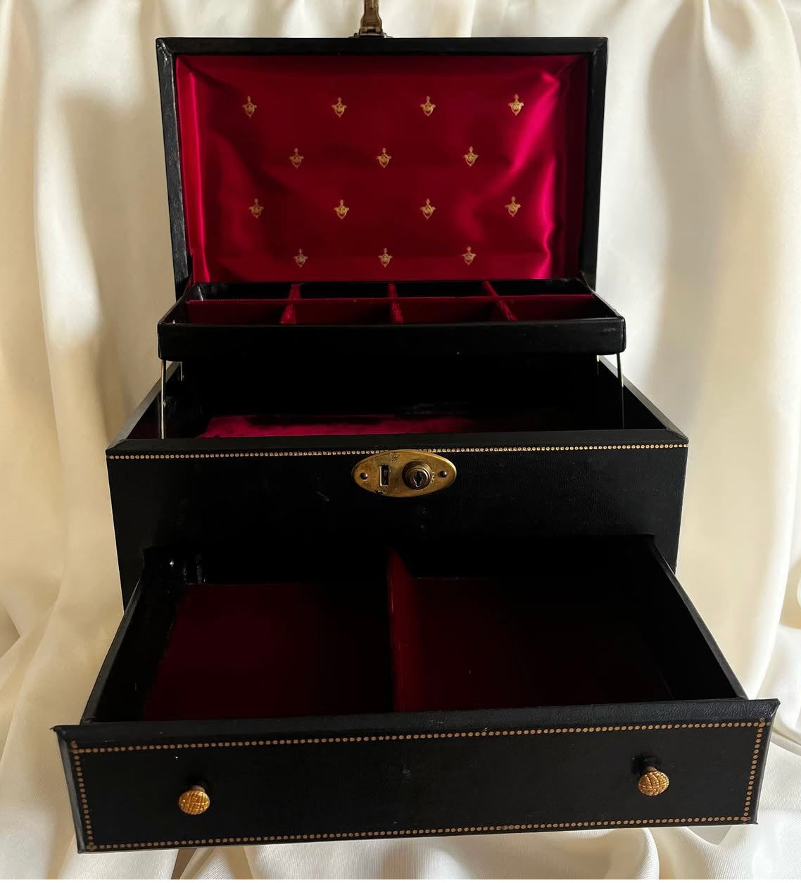 Vintage black vinyl covered jewelry box with gold accents, red velvet and satin interior