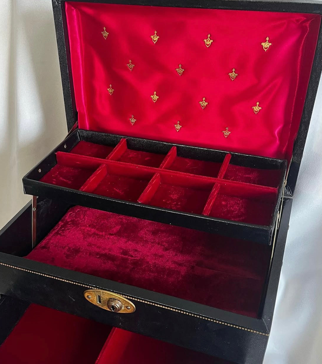 Vintage black vinyl covered jewelry box with gold accents, red velvet and satin interior