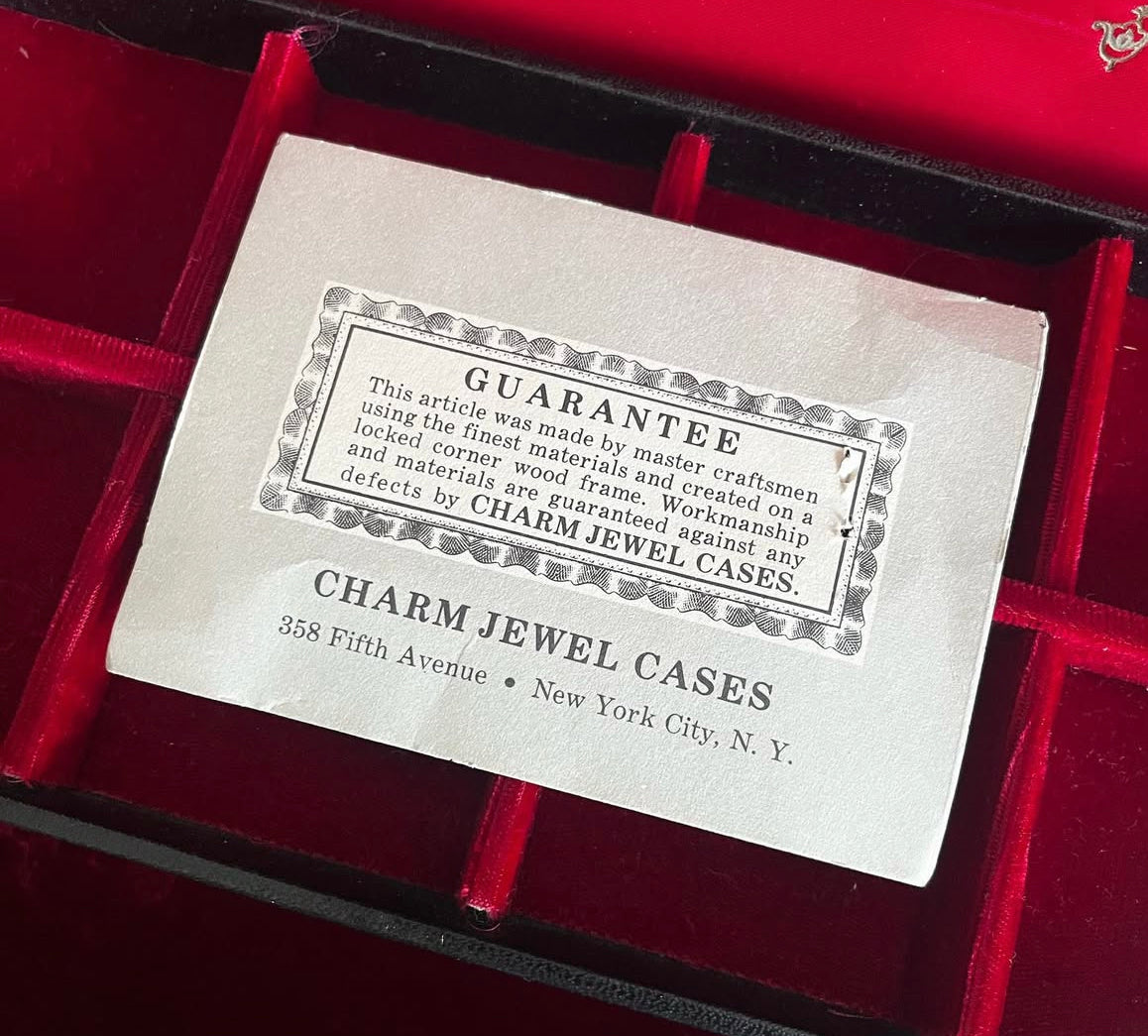 Vintage black vinyl covered jewelry box with gold accents, red velvet and satin interior